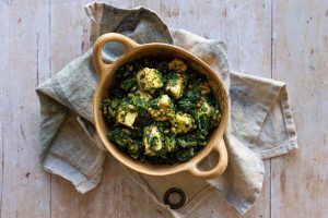 Paneer in a green salad in a ceramic bowl, sitting on a tea towel. | Featured image for Fresco Cheese.