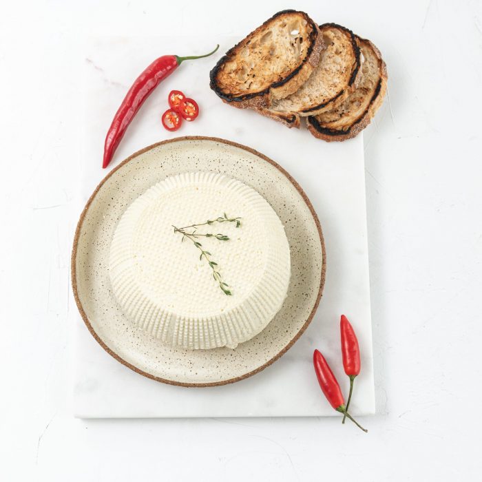Ricotta on a plate styled with chilli's and sliced bread. | Featured image for Fresco Cheese.